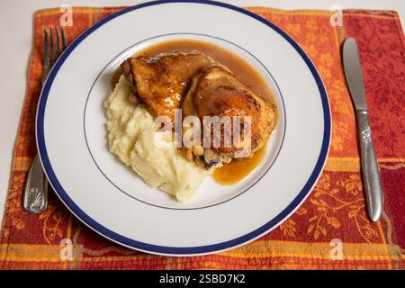 Hausgemachte gebratene goldene Hähnchenschenkel mit Buttercremepüree und hausgemachter Soße Stockfoto