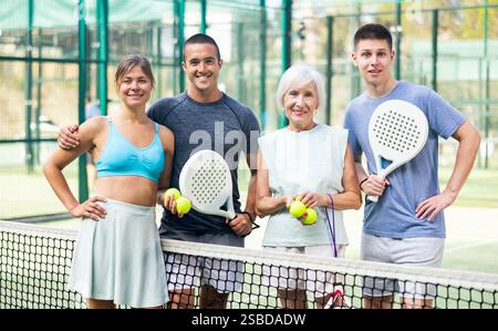 Porträt von vier glücklichen Padel-Spielern auf dem Tennisplatz im Freien Stockfoto