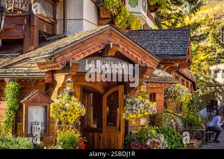 Vail, USA - 6. Oktober 2022: Ferienort im Schweizer Stil in Colorado mit Schild für Lancelot Restaurant Shop am Gore Creek Drive und Blumen Stockfoto