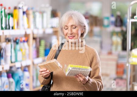 Eine Frau, die sich im Laden eine Wäschespanne ausgesucht hat Stockfoto