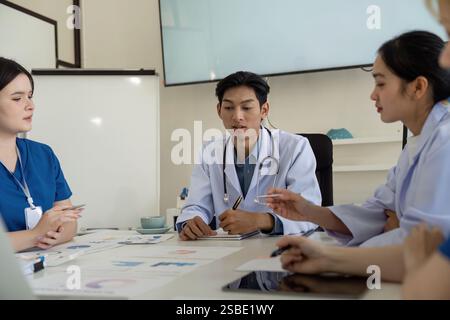 Verschiedene Ärzte arbeiten an einem Meeting zusammen, um die Patientenversorgung und -Strategien zu planen. Stockfoto