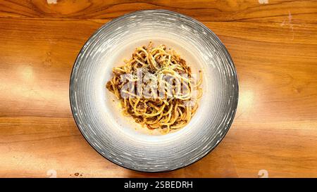 Köstliche italienische Spaghetti Carbonara auf einem Teller mit geriebenem Käse und Kräutern serviert, zeigt ein klassisches Nudelgericht, das für Foodfotografie geeignet ist, m Stockfoto