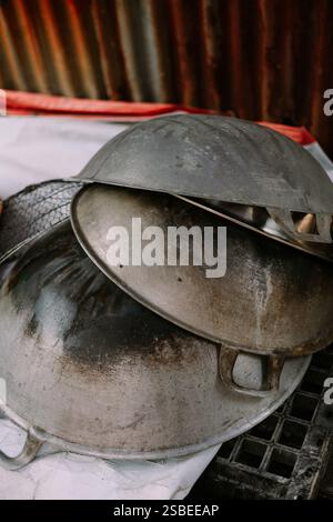 Stapel gut gebrauchter Woks mit Anzeichen von Kochen und Verschleiß. Stockfoto