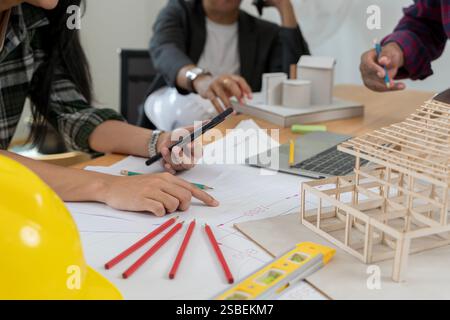 Selbstbewusste Geschäftsfrau mit Architekturmodell im Büro. Ein Meeting, um zusammenzuarbeiten und systematisch zu planen. Daten funktionieren und Tablet-Notebook. Bogen Stockfoto