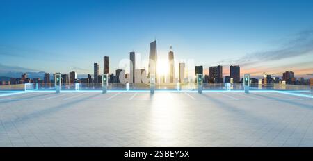 Leerer Parkplatz auf dem Dach mit EV-Ladestationen und leuchtenden Linien, mit Blick auf die moderne Skyline der Stadt bei Sonnenuntergang. 3D-Rendering Stockfoto