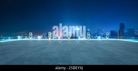 Leerer Parkplatz mit EV-Ladestationen und leuchtender Skyline der Stadt bei Nacht als Symbol für nachhaltige urbane Mobilität. 3D-Rendering Stockfoto
