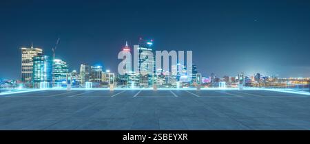 Leerer Parkplatz mit EV-Ladestationen und perth City Skyline in der Nacht. 3D-Rendering Stockfoto