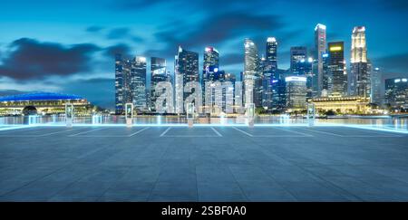 Leerer Parkplatz mit EV-Ladestationen, die vor der Kulisse der Skyline von singapur in der Dämmerung leuchten. 3D-Rendering Stockfoto