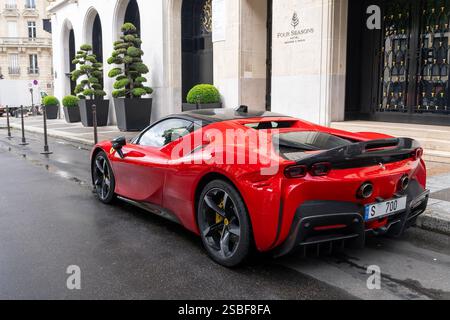 Paris, Frankreich - Blick auf einen roten Ferrari SF90 Spider Assetto Fiorano, der auf einer Straße vor einem Palast geparkt ist. Stockfoto