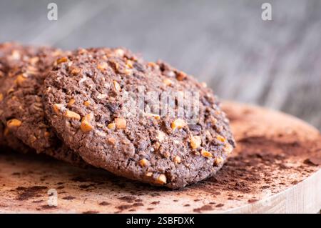 Stapel leckerer Kakaoplätzchen mit Weizen und Erdnuss auf rustikalem Tisch, handgemachte oder zubereitete Snacks Stockfoto