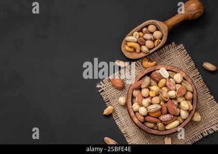 Gemischte Nüsse, getrocknete Früchte auf rustikalem Tisch, verschiedene Art von gesundem Essen Stockfoto