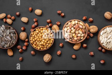 Gemischte Nüsse, getrocknete Früchte auf rustikalem Tisch, verschiedene Art von gesundem Essen Stockfoto