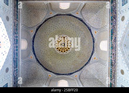 Ein atemberaubender Blick auf eine Kuppeldecke mit komplexen geometrischen Mustern und Blumenmustern, die traditionelle architektonische Kunst zeigen. Stockfoto