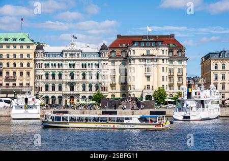 Ein Sightseeing-Boot des schwedischen Tourismusunternehmens Strömma, das auf dem Norrström in Stockholm, Schweden, vor historischen Gebäuden segelt Stockfoto