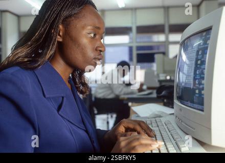 Kenia, Nairobi - weibliche Mitarbeiterin der Internetfirma KeniaWeb benutzt einen Computer im Büro. Stockfoto