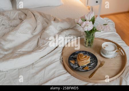Frühstück im Bett â€“ herzförmige Pfannkuchen Kaffee, Blumen und Liebeskarte Stockfoto