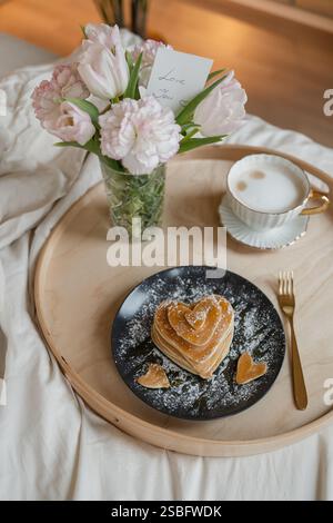 Herzförmige Pfannkuchen mit Zuckerpulver für ein Überraschungsfrühstück im Bett Stockfoto