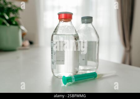 Zwei medizinische Glasflaschen mit Speisesalz und Spritze. Hochwertige Fotos Stockfoto