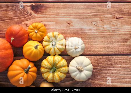 Kürbisse Herbst Hintergrund. Bunte Kürbisse auf braunem Holzhintergrund. Flache Lagen. Stockfoto