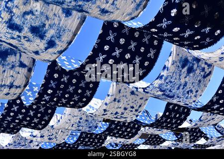 Traditionelle, weiße und blaue Stoffe der ethnischen Minderheit der Bai, die in der Wintersonne in der Altstadt von Dali, Yunnan, China, zum Trocknen aufgehängt werden Stockfoto