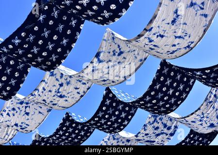 Traditionelle, weiße und blaue Stoffe der ethnischen Minderheit der Bai, die in der Wintersonne in der Altstadt von Dali, Yunnan, China, zum Trocknen aufgehängt werden Stockfoto