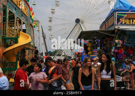 Columbus, Ohio, USA - 5. August 2023: Familien und Freunde genießen eine Sommermesse voller Attraktionen, Spiele und einem riesigen Riesenrad im Hinterland Stockfoto