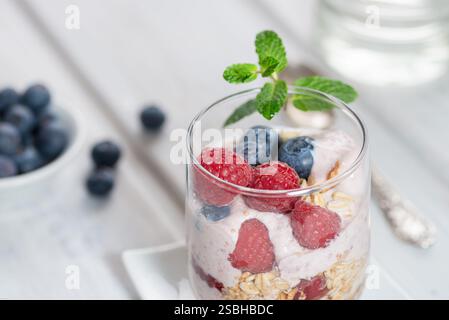 Gesundes Dessert - Himbeeren und Heidelbeeren mit Joghurt in Gläsern - Nahaufnahme Stockfoto