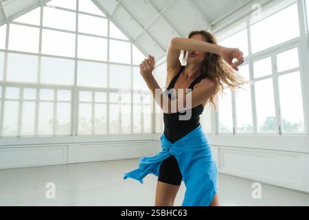 Ein Nahporträt einer Frau, die während des Tanzes ihre Arme und ihren Kopf anmutig bewegt Stockfoto