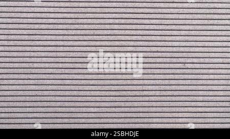 Der Stoff zeigt ein gleichmäßiges Muster aus dünnen, abwechselnden Streifen in neutralen Tönen, perfekt für verschiedene Anwendungen. Stockfoto