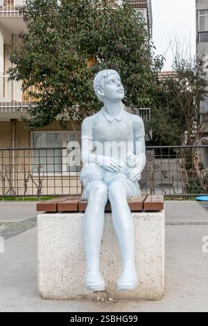 Stadtskulptur - ein junger Mann, der mit einer Katze auf einer Bank sitzt, Izmir, Türkei Stockfoto