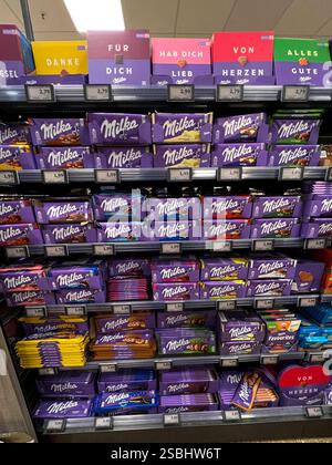 Symbolfoto - Milka Schokolade - Regale im Supermarkt Disconter mit verschiedenen Sorten Milka Alpenmich Schoholade in lilla Papier gehült mit dem Logo der Milka Kuh. Der Name ist eine Kombination der beiden Hauptzutaten Milch und Kakao. Der Kakaopreis steigt und steigt. Und das macht unsere geliebte Schoggi teurer der US-Produzent Mondelez verkleinert zahlreiche Sorten. Drastische Preiserhöhung bei einer der bekanntesten Schokoladen-Marken Verbraucherinnen und Verbraucher müssen für Schokolade der bekannten Marke Milka derzeit vielerorts tiefer in die Tasche greifen Mondelez International ist e Stockfoto