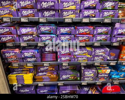 Symbolfoto - Milka Schokolade - Regale im Supermarkt Disconter mit verschiedenen Sorten Milka Alpenmich Schoholade in lilla Papier gehült mit dem Logo der Milka Kuh. Der Name ist eine Kombination der beiden Hauptzutaten Milch und Kakao. Der Kakaopreis steigt und steigt. Und das macht unsere geliebte Schoggi teurer der US-Produzent Mondelez verkleinert zahlreiche Sorten. Drastische Preiserhöhung bei einer der bekanntesten Schokoladen-Marken Verbraucherinnen und Verbraucher müssen für Schokolade der bekannten Marke Milka derzeit vielerorts tiefer in die Tasche greifen Mondelez International ist e Stockfoto