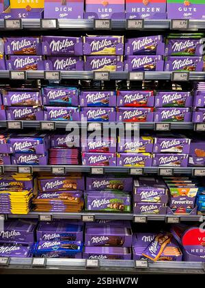 Symbolfoto - Milka Schokolade - Regale im Supermarkt Disconter mit verschiedenen Sorten Milka Alpenmich Schoholade in lilla Papier gehült mit dem Logo der Milka Kuh. Der Name ist eine Kombination der beiden Hauptzutaten Milch und Kakao. Der Kakaopreis steigt und steigt. Und das macht unsere geliebte Schoggi teurer der US-Produzent Mondelez verkleinert zahlreiche Sorten. Drastische Preiserhöhung bei einer der bekanntesten Schokoladen-Marken Verbraucherinnen und Verbraucher müssen für Schokolade der bekannten Marke Milka derzeit vielerorts tiefer in die Tasche greifen Mondelez International ist e Stockfoto