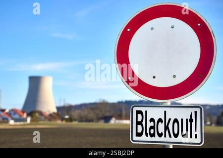 Essenbach, Bayern, Deutschland - 01. Februar 2025: FOTOMONTAGE, das Schild mit der Aufschrift Blackout vor einem Kernkraftwerk symbolisiert die Gefahr eines großen Stromausfalls aufgrund von Netzüberlastung, mangelnder Versorgungssicherheit und der Bedeutung stabiler Energiequellen. *** FOTOMONTAGE, das Schild mit der Aufschrift Blackout vor einem Atomkraftwerk symbolisiert die Gefahr eines großflächigen Stromausfalls durch Netzüberlastung, mangelnde Versorgungssicherheit und die Bedeutung von stabilen Energiequellen. Stockfoto