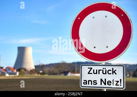 Essenbach, Bayern, Deutschland - 01. Februar 2025: FOTOMONTAGE, ein Schild mit dem Aufdruck zurück ins Netz vor einem Kernkraftwerk symbolisiert die Diskussion über die Reaktivierung von Kernkraftwerken zur Sicherung der Energieversorgung in Krisenzeiten. *** FOTOMONTAGE, ein Schild mit dem Hinweis Zurück ans Netz vor einem Atomkraftwerk symbolisiert die Diskussion um die Reaktivierung von Kernkraftwerken zur Sicherung der Energieversorgung in Krisenzeiten. Stockfoto