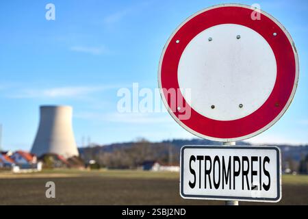 Essenbach, Bayern, Deutschland - 01. Februar 2025: FOTOMONTAGE, das Schild mit der Aufschrift Strompreis vor einem Kernkraftwerk verweist auf die Debatte über den Einfluss der Kernenergie auf die Stromkosten und die Stabilisierung der Energiepreise in unsicheren Zeiten. *** FOTOMONTAGE, das Schild mit der Aufschrift Strompreis vor einem Atomkraftwerk verweist auf die Debatte über den Einfluss von Kernenergie auf die Stromkosten und die Stabilisierung der Energiepreise in unsicheren Zeiten. Stockfoto