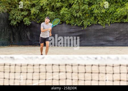 Männliches Sportlertraining für Tennis auf dem Freiluftplatz im Sommer Stockfoto