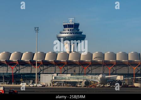 Terminal T4S, Kontrollturm und ein Jetliner am Flughafen Adolfo Suárez Madrid-Barajas, Madrid, Spanien. Stockfoto