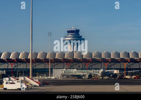 Terminal T4S, Kontrollturm und ein Jetliner am Flughafen Adolfo Suárez Madrid-Barajas, Madrid, Spanien. Stockfoto