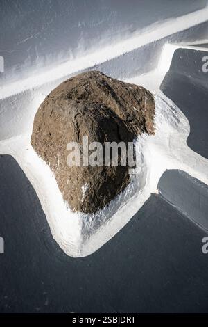Vulkanisches Gestein, eingerahmt von weißer und grauer Farbe am Boden einer Treppe auf den Klippen von Santorin, Griechenland Stockfoto