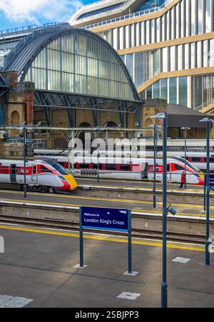 London, Vereinigtes Königreich - 13. November 2024: Bahnhof London Kings Cross - Schild und Züge auf verschiedenen Bahnsteigen Stockfoto