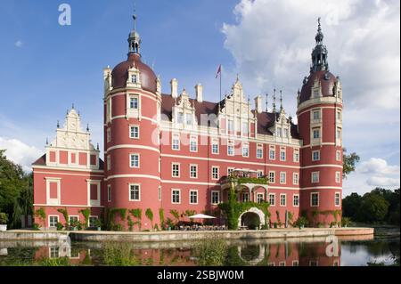 Farbenfrohe Burg spiegelt sich in einem Graben. Neues Schloss in Muskau, Bad Muskau Deutschland. Stockfoto