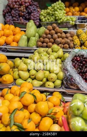 Farbenfrohe Präsentation von verschiedenen Früchten wie Birnen, Brombeeren, Kiwi, Naranjilla und mehr auf einem lebhaften Markt. Perfekt für Essen, Gesundheit und Lebensstil Stockfoto