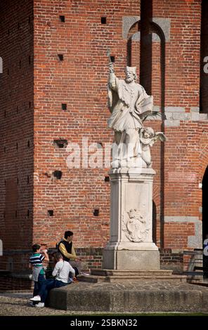 Besucher unter der Statue des Heiligen Johannes von Nepomuk im Schloss Sforza, Mailand, Italien. San Giovanni Nepomuceno. Castello Sforzesco. Johannes von Nepomuk wurde auf Befehl von König Wenzel IV. In einem Fluss ertränkt, nachdem er sich weigerte, dem König Details über den Beichtstuhl seiner Frau mitzuteilen. Die Statue ist symbolisch für die Heiligkeit des Beichtstuhls Stockfoto
