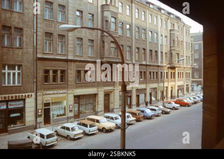 Berlin, Deutschland. Frühjahr 1984. Hausfassaden und eine Reihe von ostdeutschen Autos, hauptsächlich Trabant- und Wartburg-Autos, parken entlang der Rosa-Luxemburg Straße im ehemaligen Ostberliner Stadtteil Mitte. Stockfoto