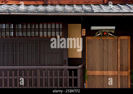 Das Holzgitter „Koshi“, das ein Fenster bedeckt, ist ein typisches architektonisches Merkmal, das man in alten Kyoto Machiya Stadthäusern in Japan findet. Stockfoto