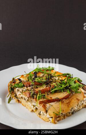 Genießen Sie die einzigartigen Aromen einer frisch gebackenen hausgemachten Pizza mit cremigem Hüttenkäse, süßen Birnenscheiben und lebendigem Rucola. Perfekt für eine Co Stockfoto