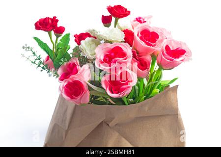 Ein wunderschöner Blumenstrauß aus leuchtenden rosa und roten Rosen, verziert in einer rustikalen Papiertüte, perfekt für besondere Anlässe und zum Ausdruck von Liebe und A Stockfoto