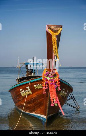 Vorderansicht eines traditionellen thailändischen Langboot mit Blumenschmuck in Krabi, Thailand, an einem sonnigen Tag. Stockfoto
