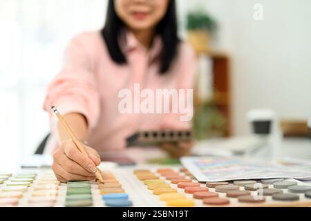 Innenarchitektin wählt Farbmuster für ein Projekt am Schreibtisch Stockfoto